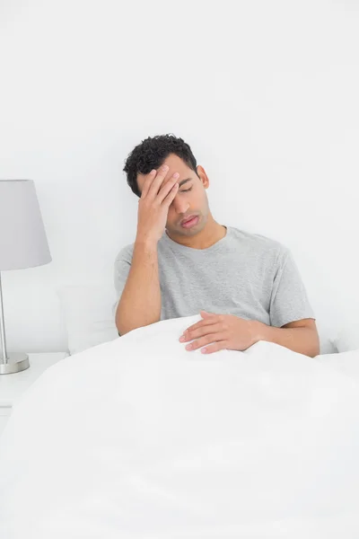 Homme souffrant de maux de tête au lit — Photo