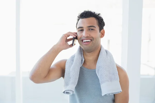 Portret van een jonge lachende man met mobiele telefoon — Stockfoto