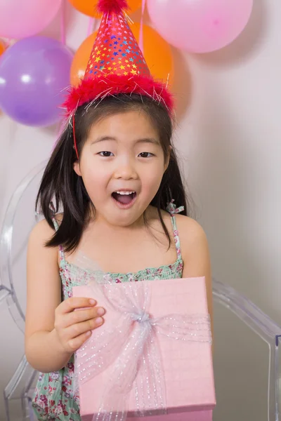 Shocked girl opening gift box at her birthday party — Stock Photo, Image