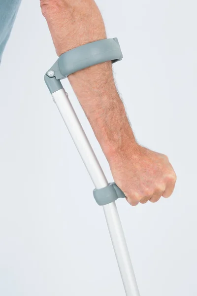 Close-up mid section of a man with crutch — Stock Photo, Image