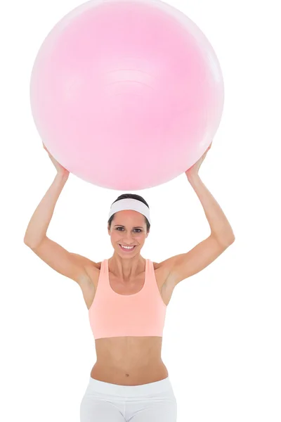 Fitness topu tutan gülümseyerek uygun bir kadın portresi — Stok fotoğraf