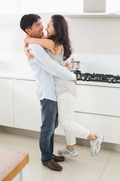 स्वयंपाकघरात स्त्री आलिंगन एक माणूस साइड दृश्य — स्टॉक फोटो, इमेज
