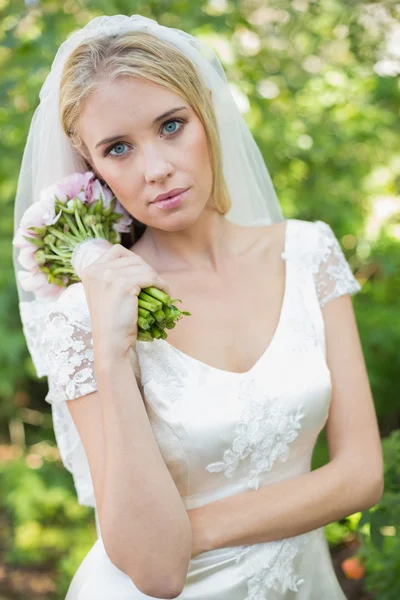 Friedliche Braut hält ihren Strauß — Stockfoto