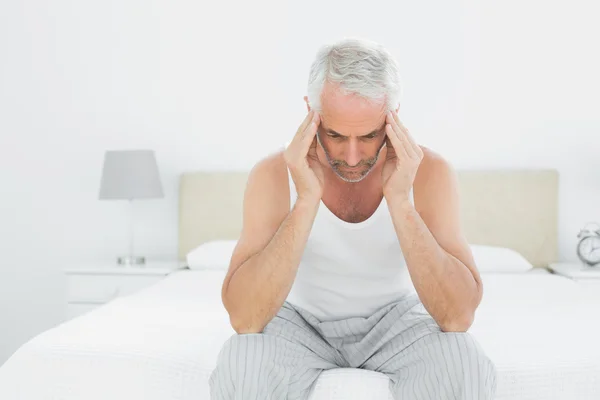 Hombre que sufre de dolor de cabeza en la cama — Foto de Stock