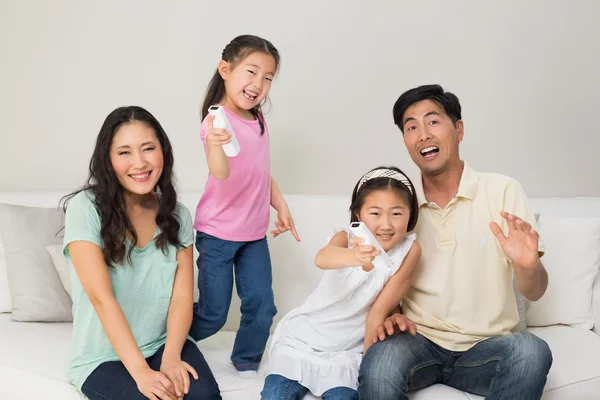 Ritratto di una famiglia di quattro persone che guarda la tv in salotto — Foto Stock
