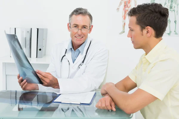 Doctor explicando la radiografía pulmonar al paciente en el consultorio —  Fotos de Stock