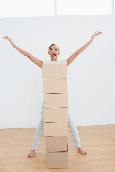 Woman shouting with stack of boxes in a new house — Stock Photo, Image