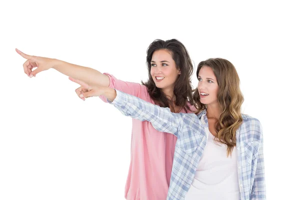 Friends pointing away against white background — Stock Photo, Image