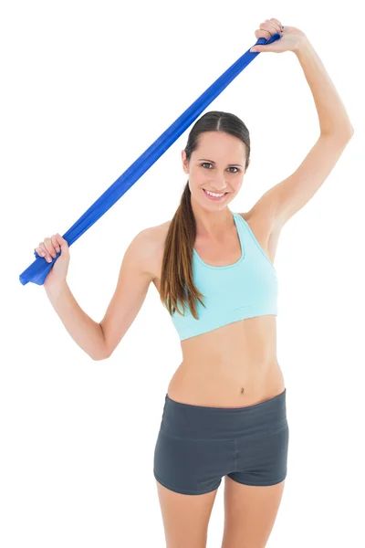 Gülümseyen genç kadın mavi yoga kemer tutarak uygun — Stok fotoğraf