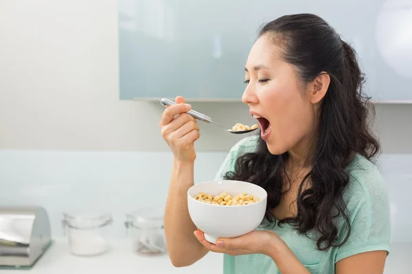 Mujer joven comiendo cereales en la cocina —  Fotos de Stock