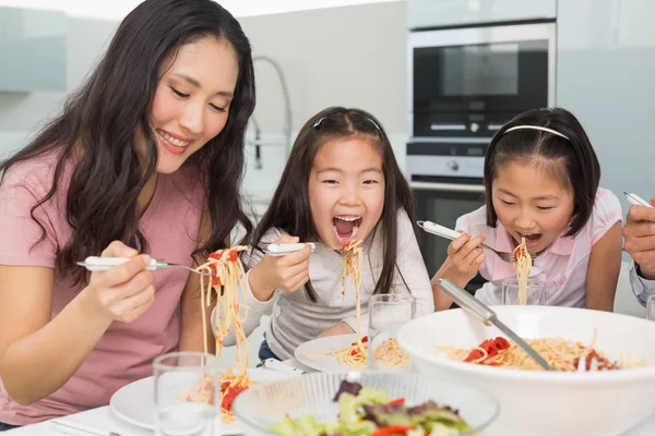 台所でスパゲティ ランチを楽しんでいる子供と女性 — ストック写真