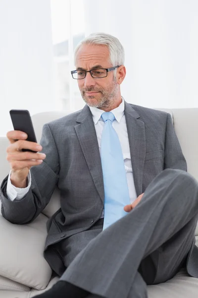 Elegant mogna affärsman textmeddelanden på soffa — Stockfoto