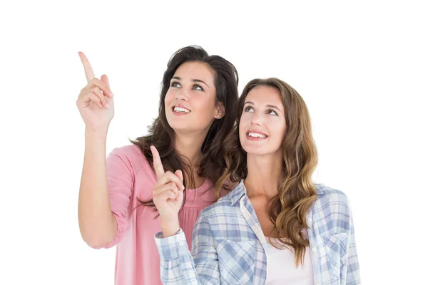 Friends pointing up against white background — Stock Photo, Image