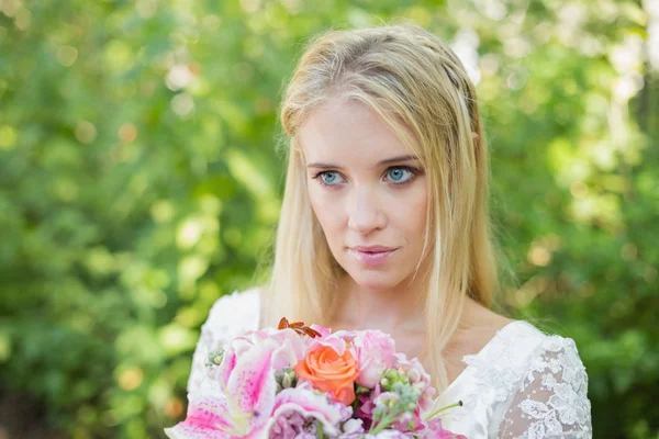 Bionda sorridente sposa tenendo bouquet — Foto Stock