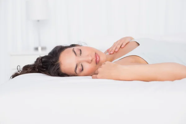 Pretty young woman sleeping with eyes closed in bed — Stock Photo, Image