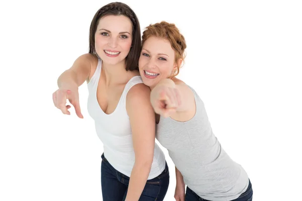 Female friends pointing against white background — Stock Photo, Image