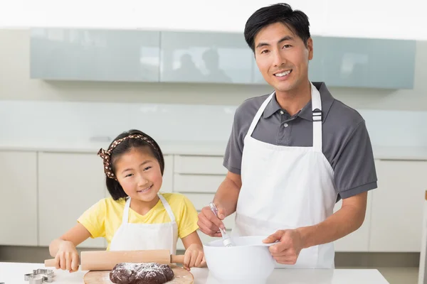 Человек со своей дочерью готовит печенье на кухне — стоковое фото