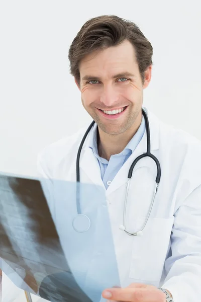 Médico masculino concentrado mirando la imagen de rayos X de la columna vertebral —  Fotos de Stock