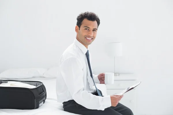 Geschäftsmann mit Tasse Zeitung im Hotelzimmer — Stockfoto