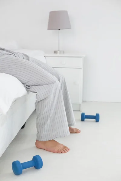 Genç bir adam yatakta yatarken pijama içinde düşük bölümü — Stok fotoğraf