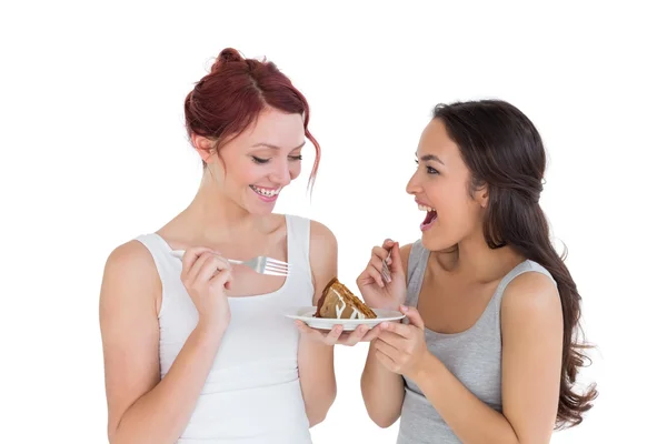 Vrolijke jonge vrouwelijke vrienden gebak samen eten — Stockfoto