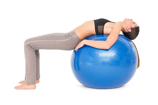 Sidovy av en vältränad kvinna stretching på fitness boll — Stockfoto