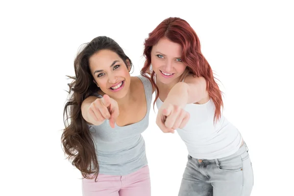 Happy young friends pointing against white background — Stock Photo, Image