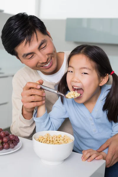 Far med unga dotter med spannmål i kök — Stockfoto