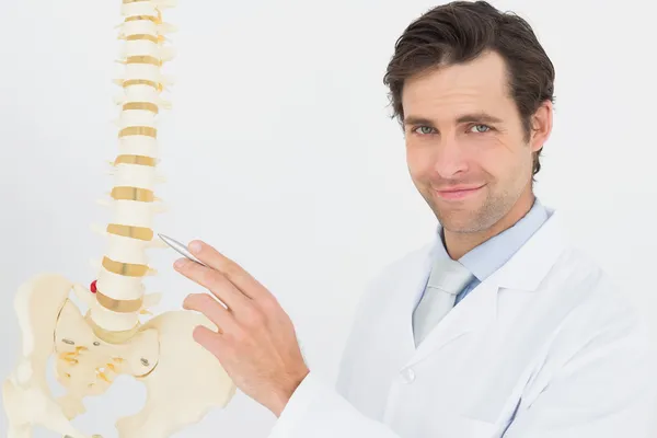 Retrato de un médico varón sonriente con modelo esquelético — Foto de Stock