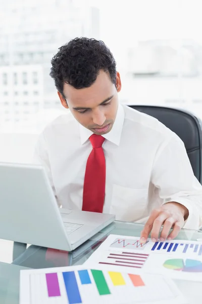 Empresario con portátil trabajando en gráficos en el escritorio — Foto de Stock