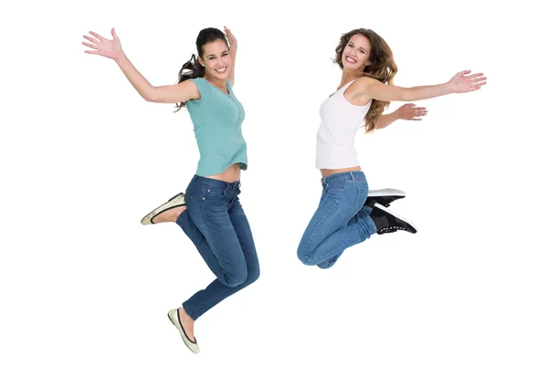 Two cheerful young female friends jumping — Stock Photo, Image
