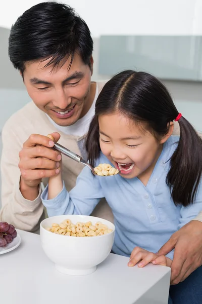 Far med unga dotter med spannmål i kök — Stockfoto