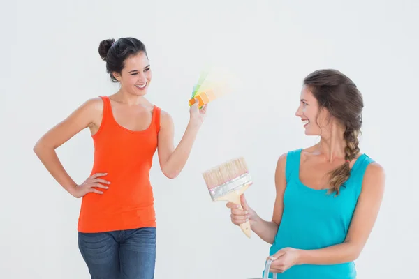 Amigos con pincel escogiendo el color para pintar una habitación —  Fotos de Stock