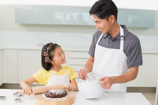 台所でクッキーを準備する彼の娘と笑みを浮かべて男 — ストック写真