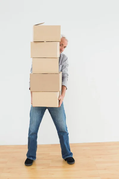 Mature man carrying boxes in a new house — Stock Photo, Image