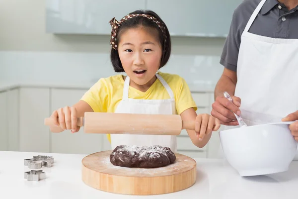 Шокированная девушка со своим отцом готовит печенье на кухне — стоковое фото