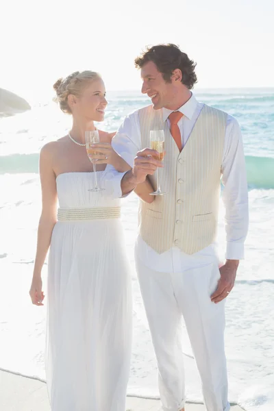 Novomanželé přípitky šampaňským se usmívá na kameru — Stock fotografie