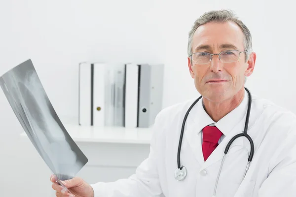 Arzt betrachtet Röntgenbild der Lungen im Büro — Stockfoto