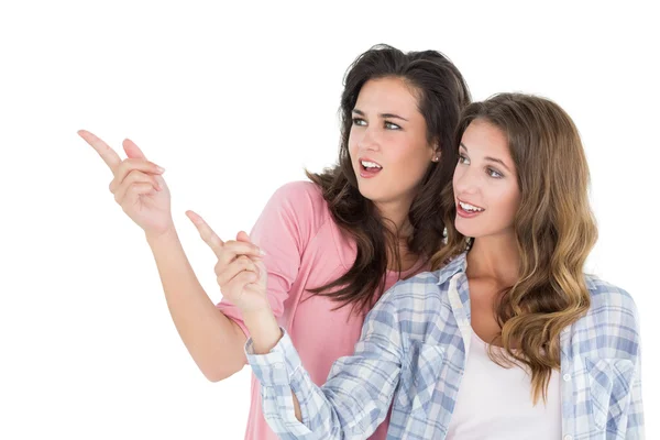 Friends pointing away against white background — Stock Photo, Image