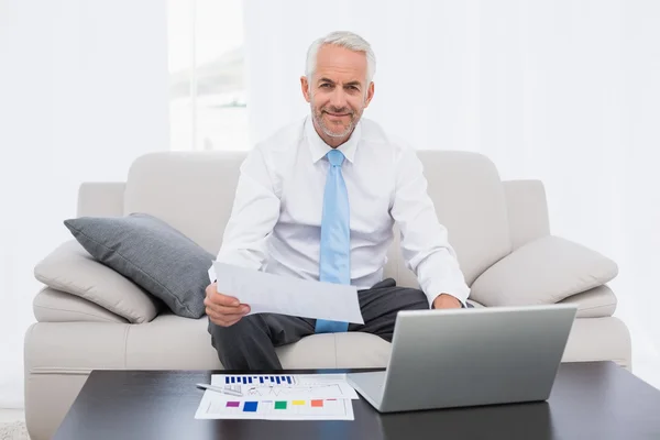 Affärsman som arbetar på grafer och laptop hemma — Stockfoto