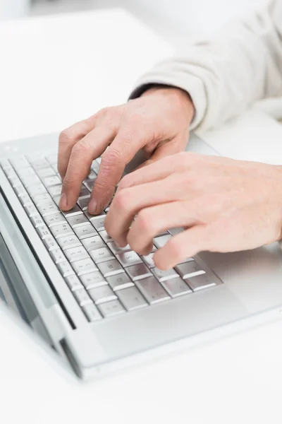 Mãos usando laptop na superfície branca — Fotografia de Stock