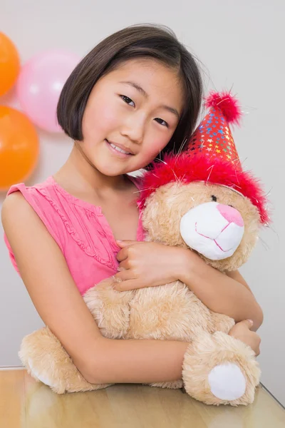 Bonito menina abraçando brinquedo macio em uma festa de aniversário — Fotografia de Stock