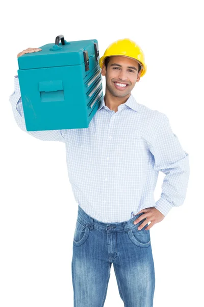 Portrait of a smiling handyman in hard hat carrying a toolbox — Stock Photo, Image