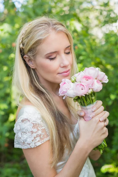 Blonde bride smelling her bouquet — Stock Photo, Image