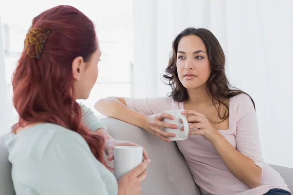 Jóvenes amigas charlando sobre el café en casa —  Fotos de Stock