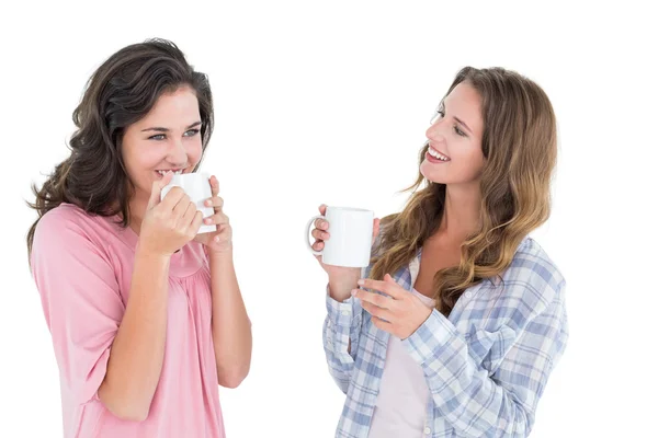 Twee jonge vrouwelijke vrienden drinken koffie glimlachen — Zdjęcie stockowe
