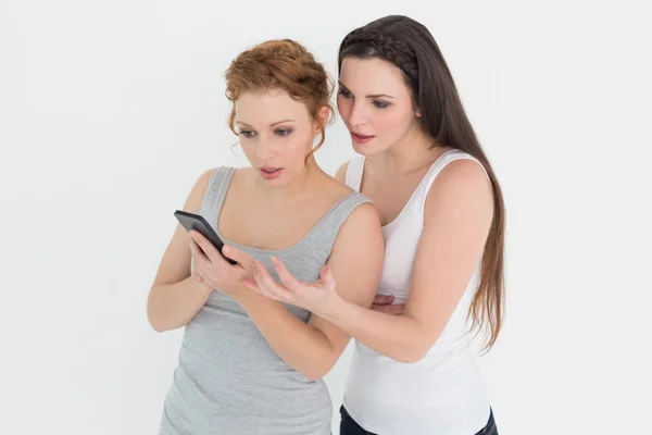 Duas jovens amigas casuais olhando para o telefone celular — Fotografia de Stock