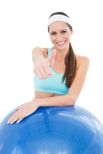 Mujer sonriente en forma con pelota de fitness gestos pulgares hacia arriba —  Fotos de Stock