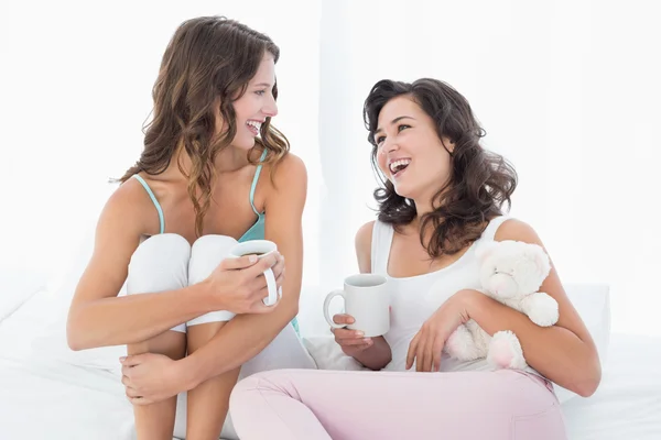 性格开朗的女性朋友与躺在床上的咖啡杯 — 图库照片