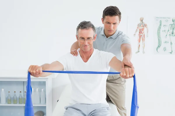 Therapist massaging mans shoulder in gym hospital — Stock Photo, Image